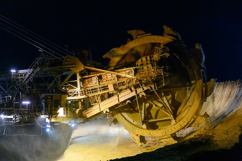 A bucket wheel excavator mines lignite in the open pit mine Garzweiler at night.